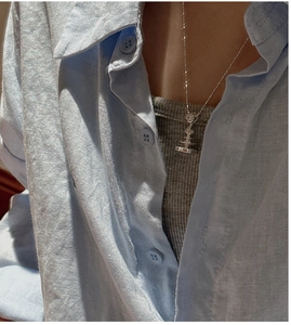 Detail view of S925 sterling silver fountain necklace worn on a light blue shirt
