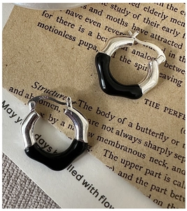 Detailed shot of S925 sterling silver wave hoop earrings with black enamel glaze finish