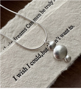 Close-up of S925 silver necklace featuring three organic pebble-shaped pendants and snake chain