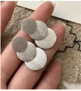 Detailed macro view of S925 sterling silver earrings with brushed matte triple circle disks
