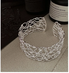 Detailed view of 925 sterling silver hollow mesh bangle with artistic branch texture