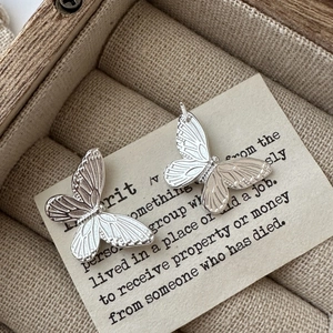 S925 sterling silver butterfly earrings with textured details on a vintage wooden box