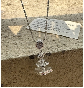Macro detail of S925 silver fountain pendant with round zircon on a stone backdrop