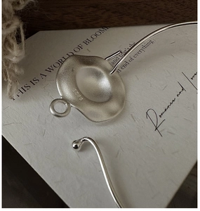 Macro shot of S925 sterling silver stamp on matte irregular wavy pendant detail