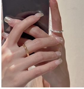 Detail of minimalist S925 sterling silver rings in gold and silver finish on hand