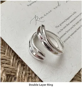 Detailed view of S925 sterling silver double-layered open ring on minimalist paper