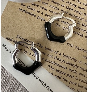 Detailed close-up of S925 sterling silver earrings with irregular wave shape and black enamel