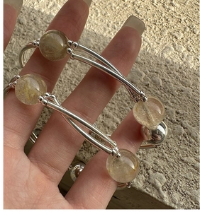 Detailed close-up of S925 sterling silver rutilated quartz stretch bracelets on hand