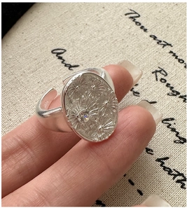 Detailed close-up of S925 sterling silver ring with engraved daisy and zircon stone