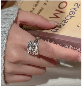 Detail of S925 sterling silver multilayer crossover ring worn with elegant styling