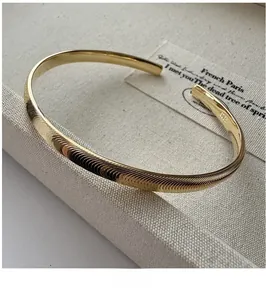 Gros plan sur le bracelet jonc en argent S925 doré avec gravures en spirale œil-de-chat