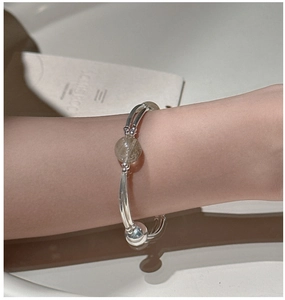 Macro detail of S925 sterling silver rutilated quartz stretch bracelet on wrist