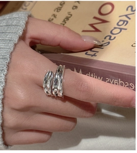 Detailed view of an S925 sterling silver criss-cross ring worn on a finger