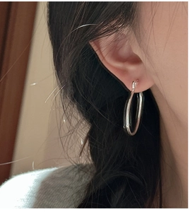 Primo piano di orecchini a cerchio minimalisti in argento sterling S925 da donna