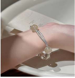 Detail of S925 sterling silver tube bracelet featuring Rutilated Quartz crystal beads