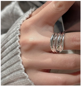 Close-up of a three-layer overlapping silver S925 sterling silver ring worn on finger