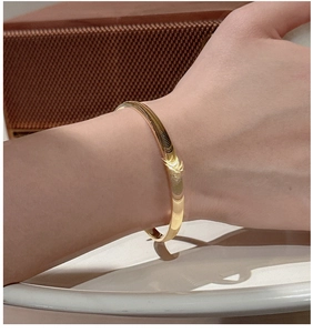 Gros plan détaillé du bracelet en argent S925 doré avec motif ondulé porté au poignet