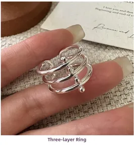 Macro shot of triple-layer silver spiral ring with beads on a textured background