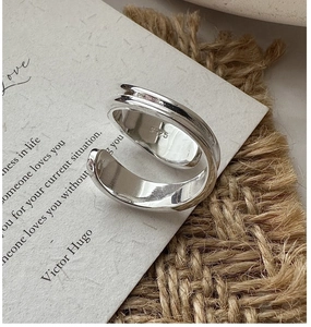 Detailed close-up of S925 sterling silver stamp on the polished minimalist crossover ring