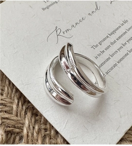 Detailed macro shot of a sleek S925 sterling silver layered cross ring on a textured card