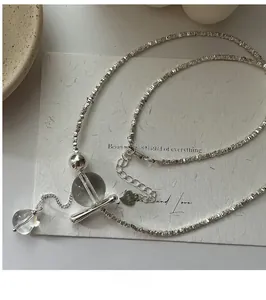 Close-up of S925 sterling silver tassel necklace with crystal beads and T-bar clasp