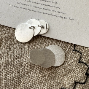 Minimalist S925 sterling silver triple disc earrings with brushed matte finish on linen