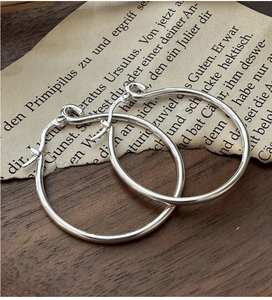 Dettaglio di orecchini a cerchio in argento sterling 925 con marchio inciso