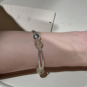 Minimalist S925 silver stretch bracelet with natural rutilated quartz beads on a model's wrist