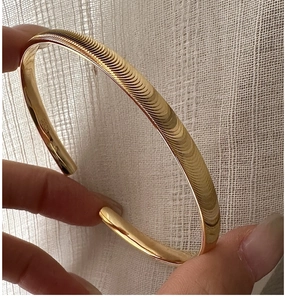 Détail d'un bracelet en argent S925 doré avec une texture gaufrée horizontale unique