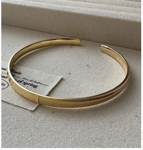 Vue détaillée du bracelet jonc doré en argent S925 avec finitions texturées et polies