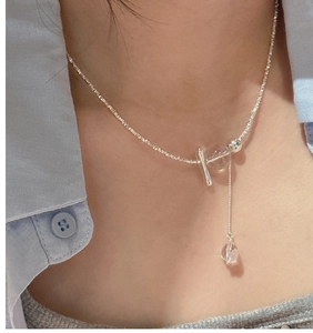 Detail of S925 sterling silver tassel necklace with clear crystal beads on a model collarbone