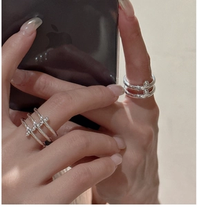 Close-up of minimalist S925 sterling silver layered rings with small bead detailing