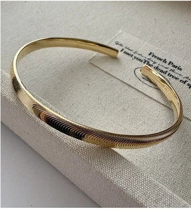 Vue détaillée du bracelet jonc doré en argent S925 avec texture ondulée et poinçon S925
