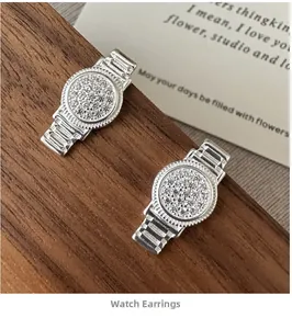 Détail de boucles d'oreilles S925 en forme de montre argentée avec oxydes de zirconium