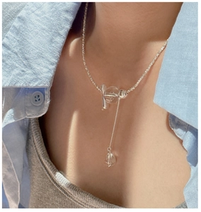 Close-up of S925 silver necklace featuring a crystal bead and tassel pendant on the neck