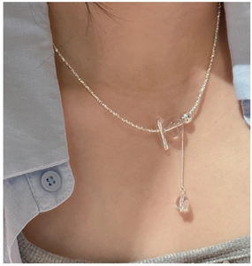 Close-up of S925 sterling silver tassel necklace with clear crystal pendant on a model