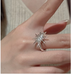Detailed close-up of a S925 sterling silver starburst ring worn on a person's finger