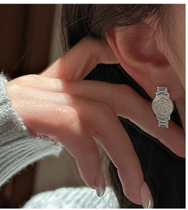 Détail d'une boucle d'oreille montre en argent S925 sertie de zircons sur mannequin