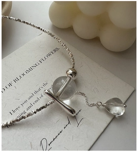 Detail of silver S925 necklace with crystal beads and tassel on art card backdrop