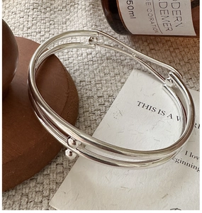 Macro detail of minimalist S925 sterling silver multi-layer cuff bracelet with polished beads