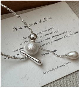 Macro detail of S925 silver necklace with frosted beads and drop pearl pendant