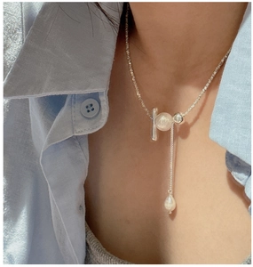 Detail of S925 sterling silver tassel necklace with beads and pearl on model