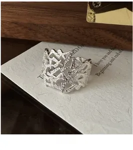 Macro shot of silver textured hollow ring with irregular lines on minimalist card