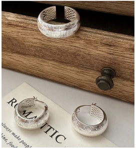 Detailed macro of S925 sterling silver ring and earrings with vertical striped texture