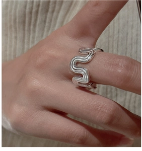 Macro detail of S925 sterling silver wavy ring featuring elegant minimalist textured curves