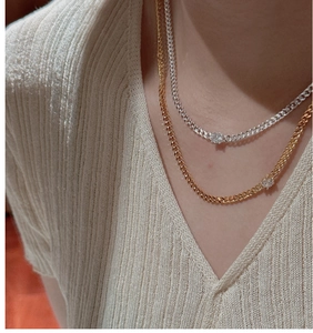 Layered gold and silver Cuban link necklaces with round clear crystals on neck