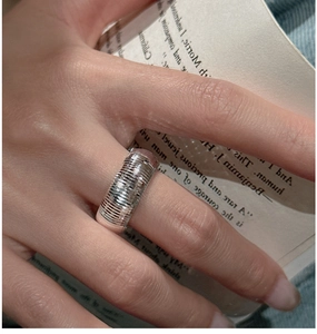 Detail of minimalist S925 silver wide band ring with vertical textured grooves