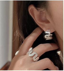 Macro shot of silver wave textured ring and earring set with polished S925 finish