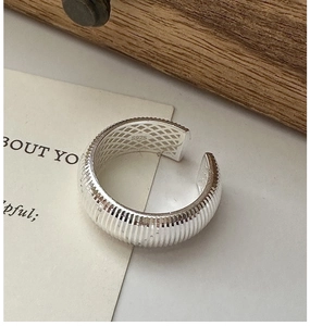 Macro detail of S925 sterling silver ring featuring pleated texture and geometric mesh