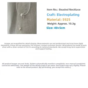 Detail of S925 sterling silver beaded necklace with frosted bead and elegant metal tassel